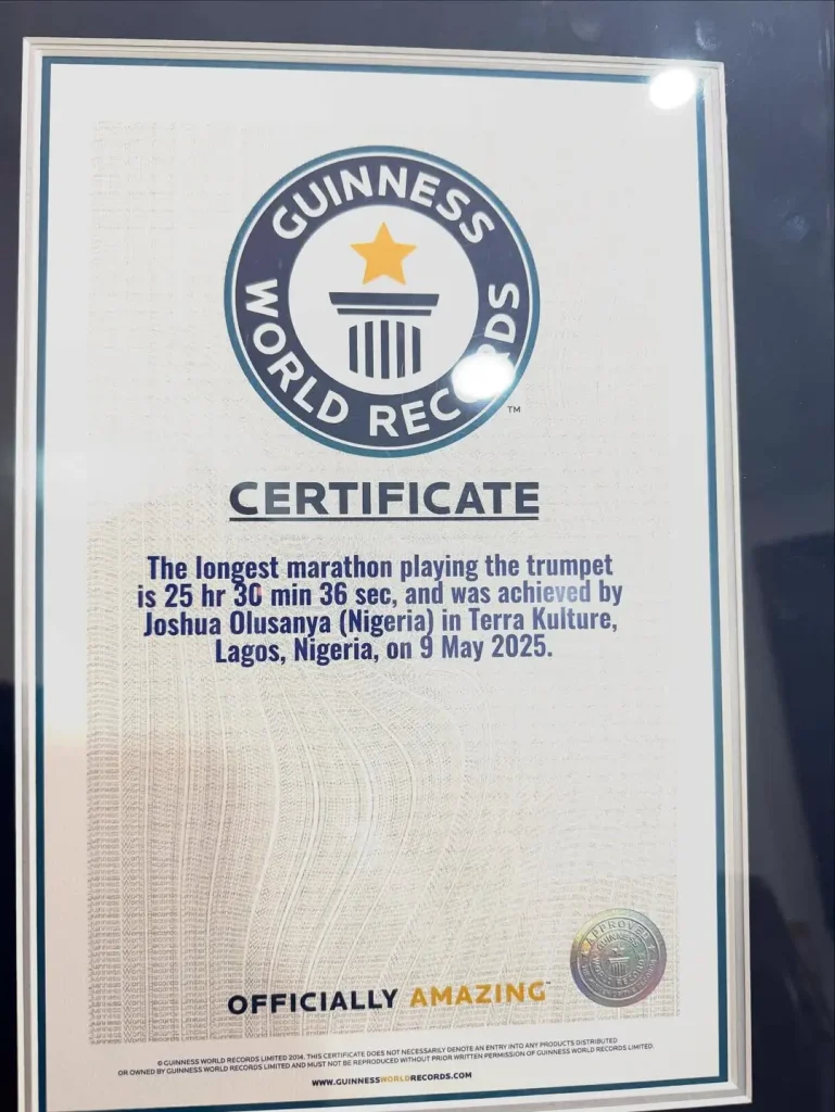 Joshua Olusanya presenting his Guinness World Record certificate to Ayo Animashaun at HipTV